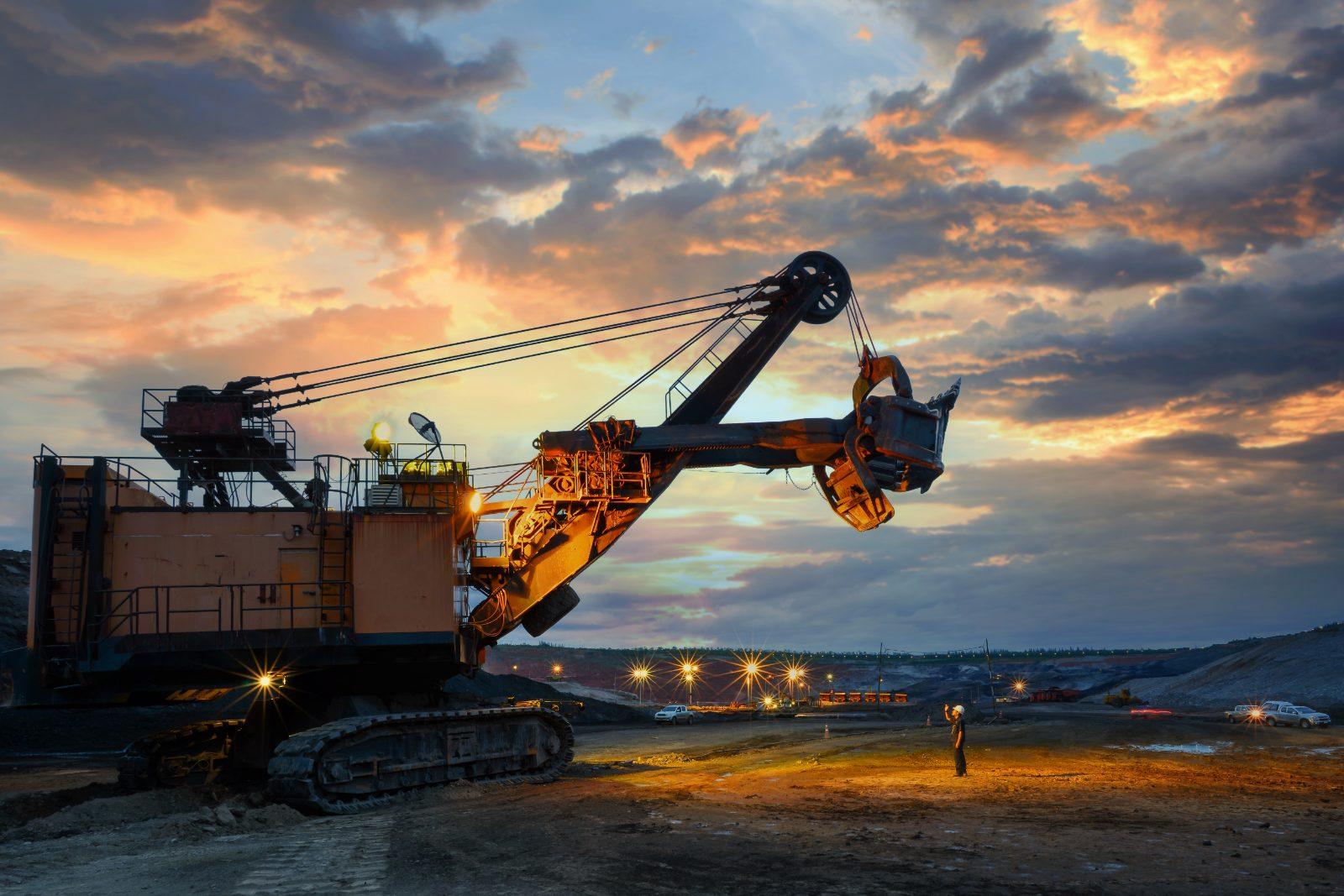 Mining excavator silhouetted at sunset