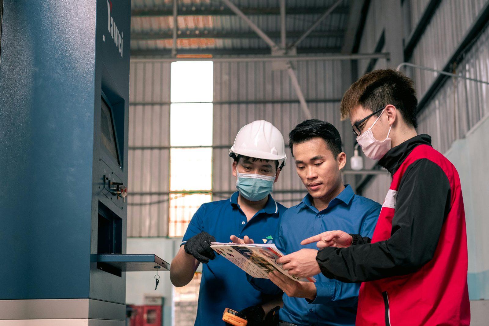 Team in full cleanroom PPE reviewing results on a tablet